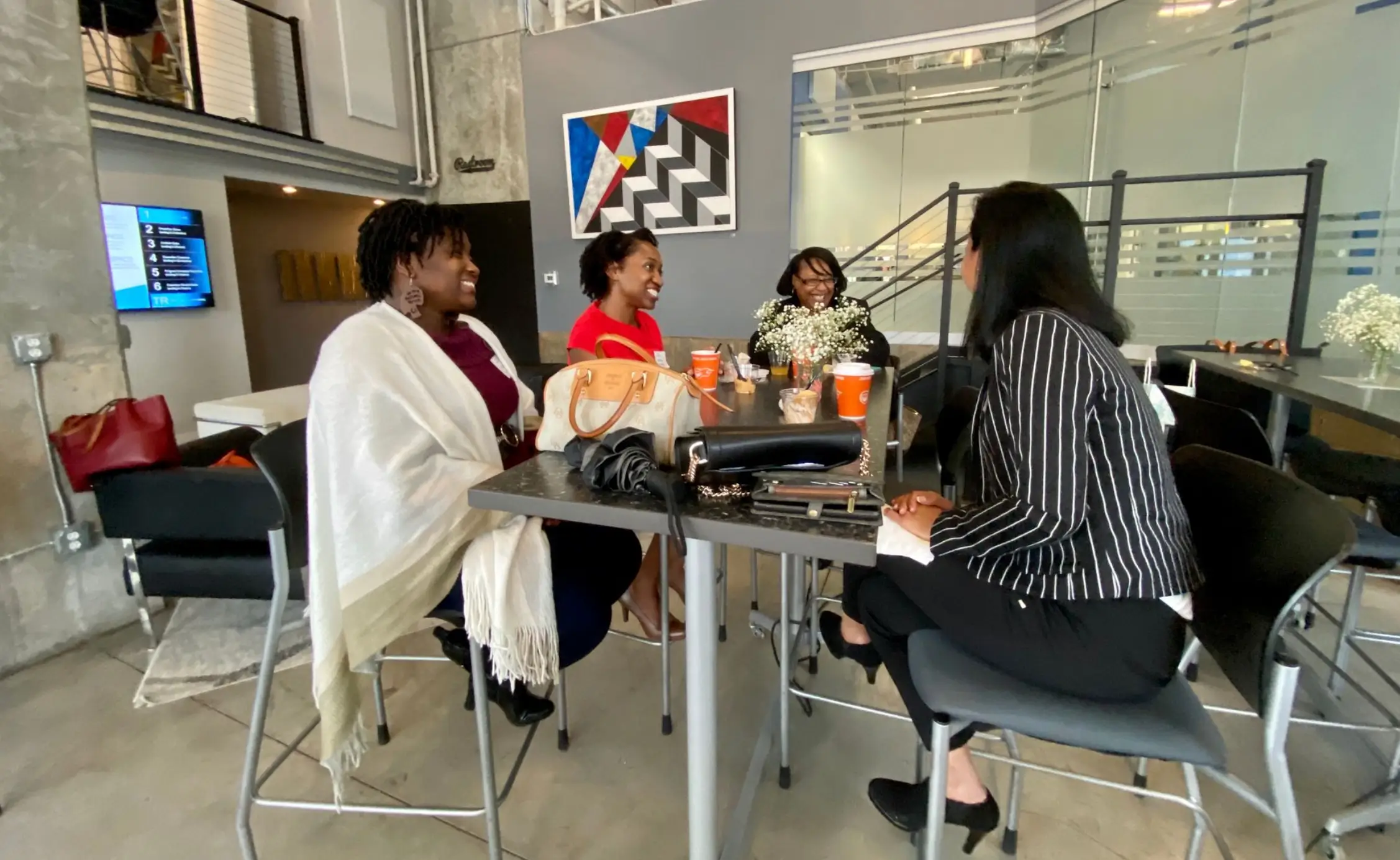 Members chatting over coffee at a shared table